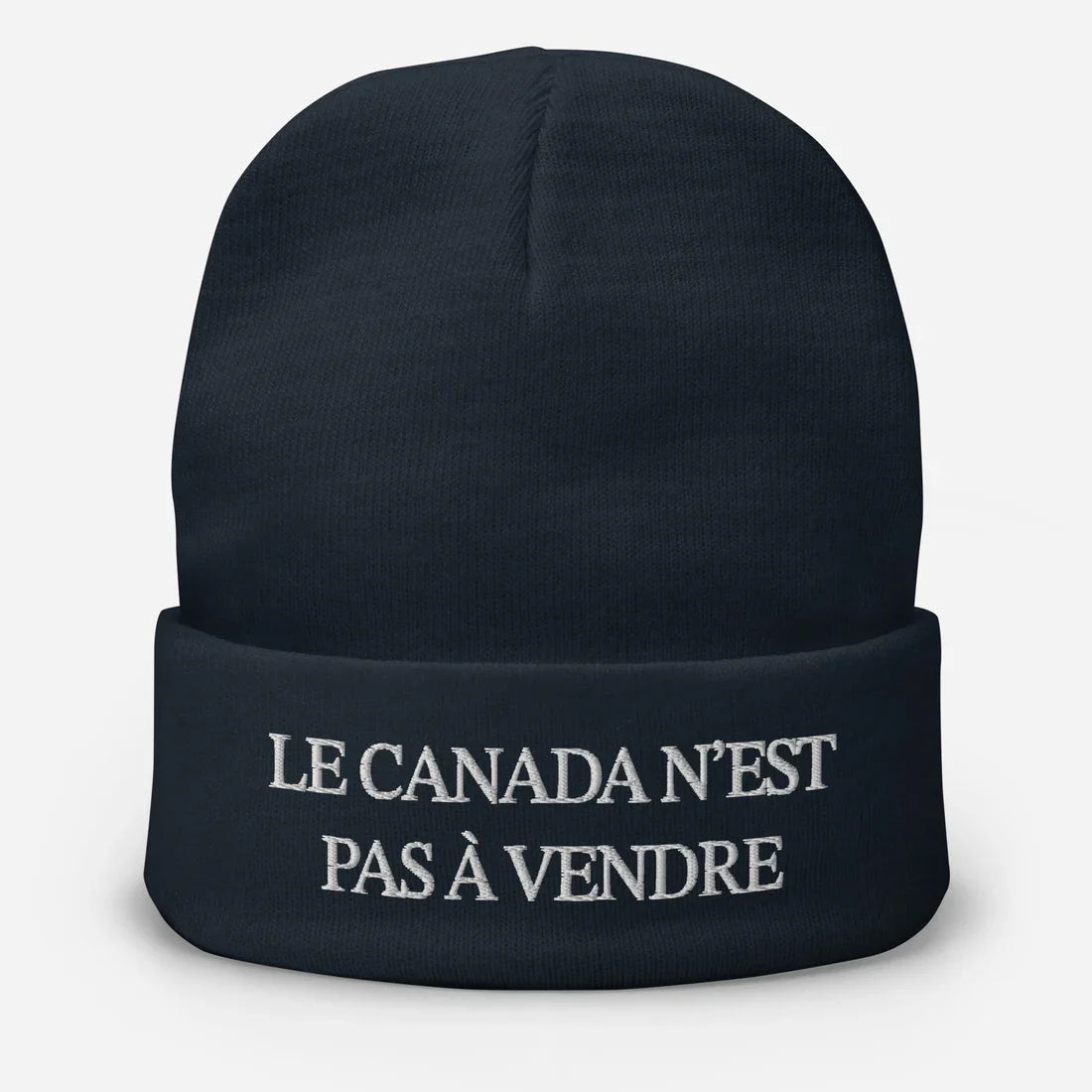 Navy blue beanie with embroidered text from Le Canada n’est pas à vendre tuque, ideal for custom apparel and screen printing
